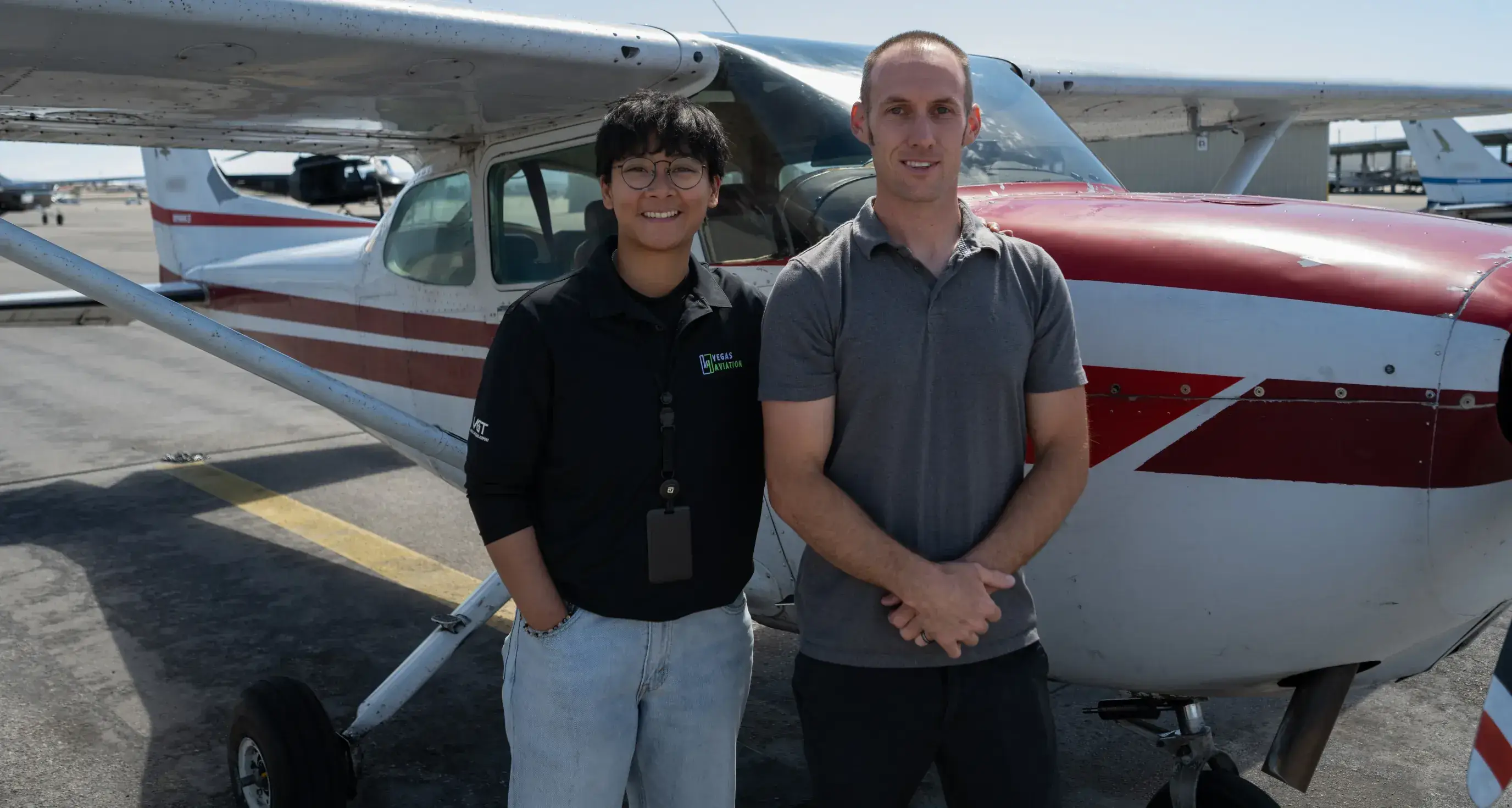 Student and instructor standing beside a Vegas Aviation airplane